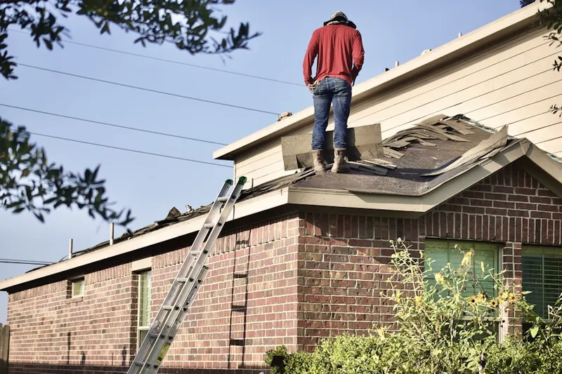 Professional roofer working on a residential roof in Raintree